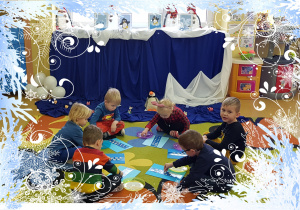 Dzieci siedzą na dywanie, układają pingwiny.
